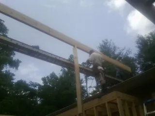 Carpenter setting a ridge beam over a new addition frame — Ice Dam Removal by Roofing Brothers in Thornwood