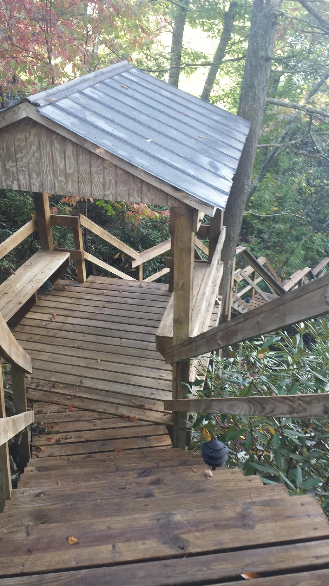 Metal roofed shelter over wooden steps on a wooded walkway — Skylight Repair & Installation work by our crew in Thornwood
