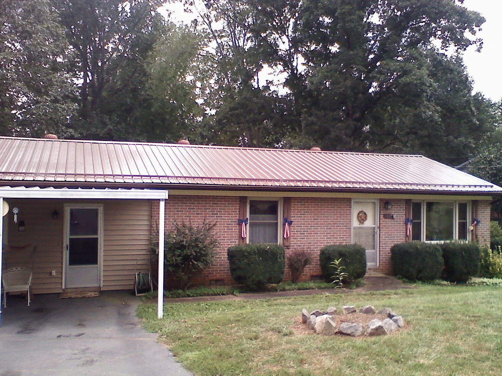 Bronze metal roof and carport on a brick ranch home — Roof Repair work by our crew in Thornwood